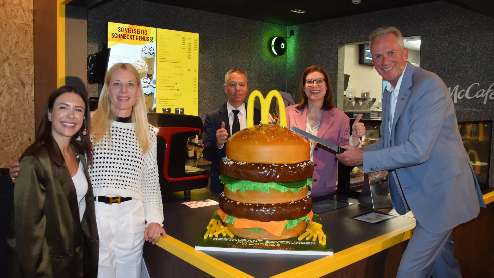 Das feierliche Anschneiden der Torte gehört zu einem Grand Opening einfach dazu - und welche Form sollte eine solche Torte schon haben außer der eines riesigen Burgers? Selbstredend vollauf essbar. (Foto: Marc Otto)