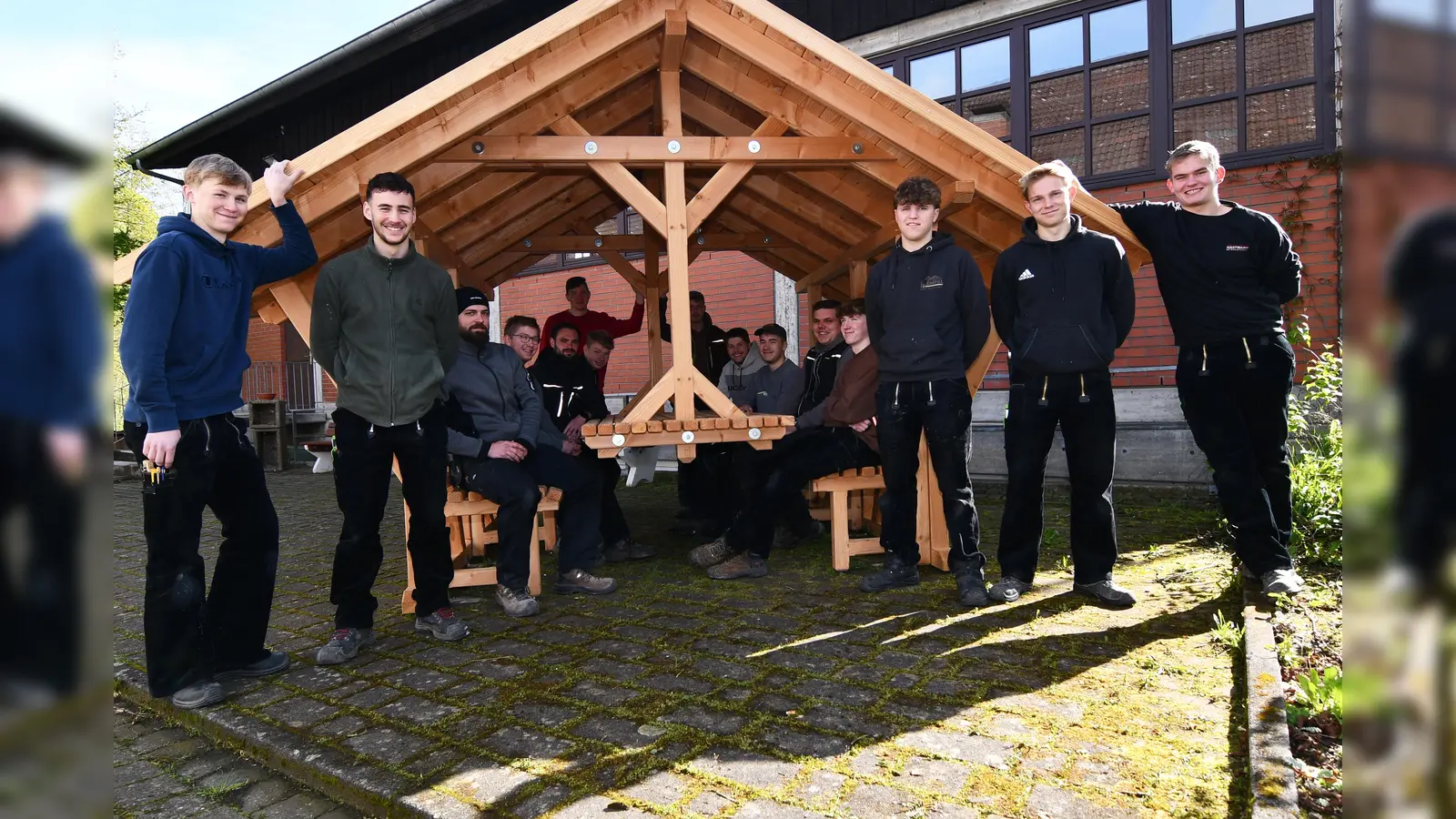 Diese Auszubildenden des Zimmerer-Handwerks haben den großzügigen Pavillon aus robusten und wetterfestem Douglasienholz selbst geplant, gestaltet und in 14 Tagen gemeinsam gebaut. Nun verschönt das Unikat den Hof des übertrieblichen Ausbildungszentrum in Brakel-Istrup. (Foto: Stefan Köneke)