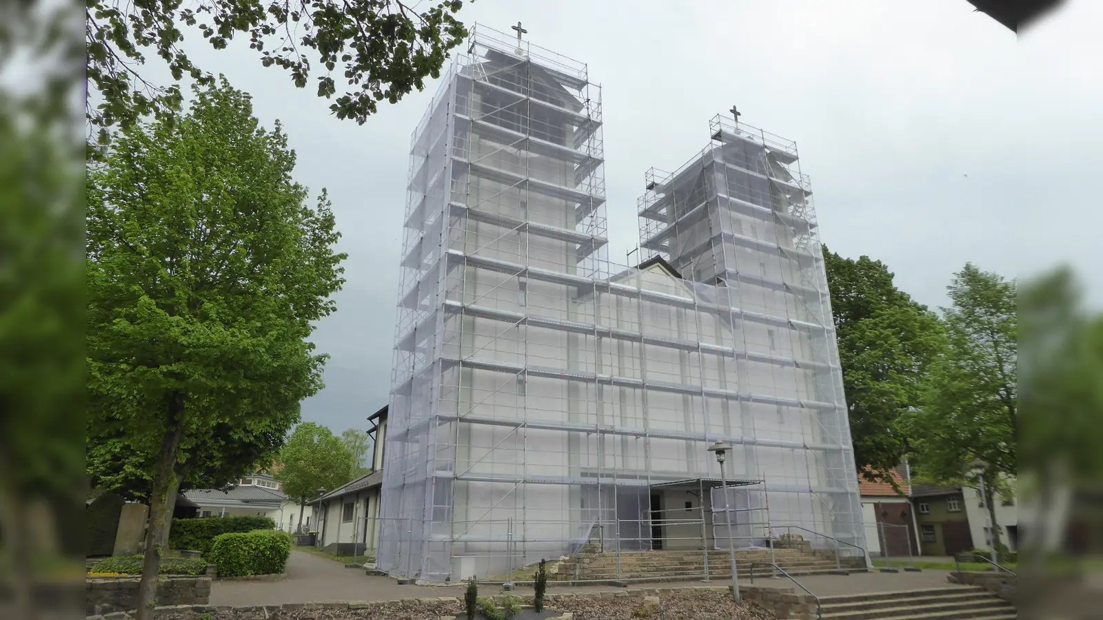 Kirchenführung mit „Christo-Erlebnis“: aktuell ist die Doppelturmfassade der Bökendorfer Pfarrkirche für anstehende Renovierungsarbeiten zwar eingerüstet und verpackt, aber das ist für die Kirchenführung im Innenraum der „kleinen Schwester von Corvey“ nicht hinderlich. (Foto: Bernhard Aufenanger)