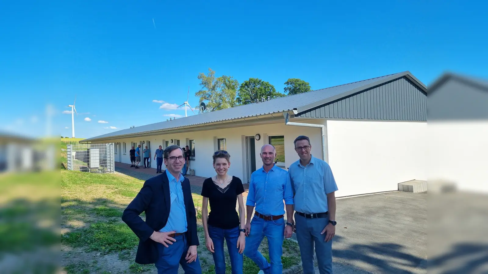 Bürgermeister Tobias Scherf, Kira Blömeke und Christian Lewin (beide Stadt Warburg, Bereich Soziales) sowie der erste Beigeordnete Andreas Niggemeyer vor der neu errichteten Asylunterkunft in Dössel am Horenberg.  (Foto: Stadt Warburg)