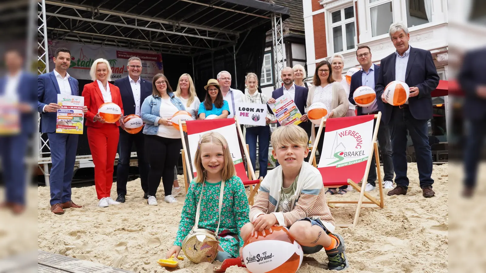 Die Beteiligten haben das vielseitige Programm am Brakeler Stadtstrand vorgestellt. Mathea (links) und Jascha freuen sich schon auf die Aktionen für Kinder. (Foto: Stadt Brakel)