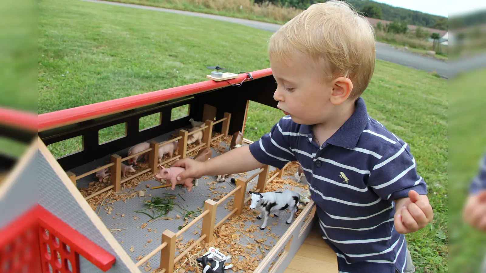 Hannes (2) spielt mit dem Bauernhof, der das letzte Projekt von Wilfried Rusche war, bevor dieser Anfang 2023 überraschend verstarb. (Foto: privat)