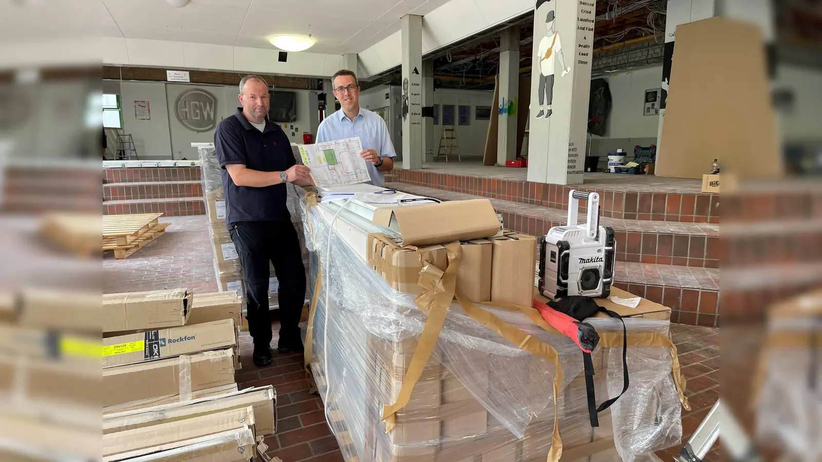 Während der Sommerferien herrscht reger Baustellen-Betrieb in den Schulen der Hansestadt Warburg: Ulrich Klare (l.), Leitung des Bereichs Bauen und Stadtentwicklung, und der erste Beigeordnete Andreas Niggemeyer stehen hinter dem Material, mit dem die offen liegenden Decken des Hüffertgymnsiums jetzt verkleidet werden.  (Foto: Stadt Warburg)